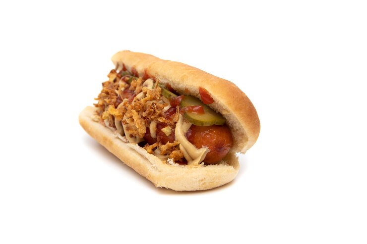 Foto autêntico cachorro-quente, salsicha com ketchup e mostarda, cebola tostada e picles em fatias finas.