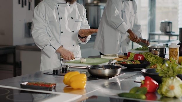 Auténtico chef cocinando comida vegetariana con diente de ajo