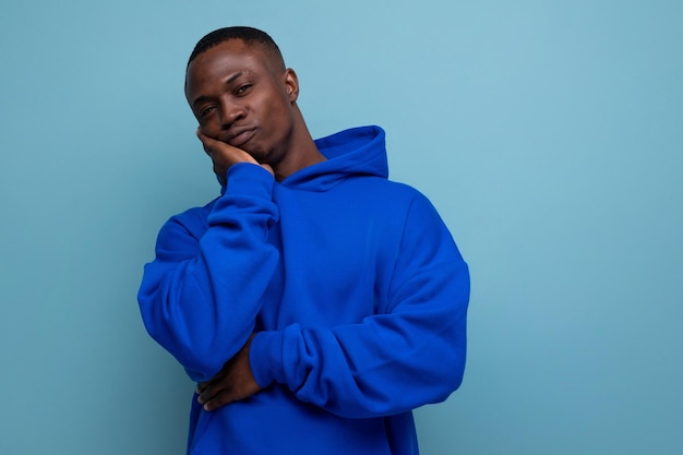 Auténtico joven africano de moda con sudadera en el fondo del estudio con espacio para copiar