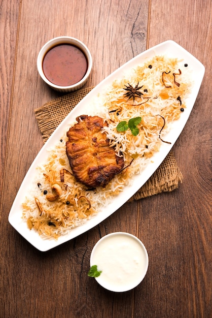 Auténtico pescado Biryani servido en un plato blanco sobre fondo blanco, enfoque selectivo