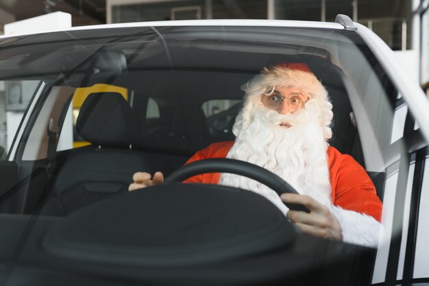 Auténtico Santa Claus conduciendo su coche moderno, al aire libre