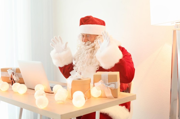 Auténtico Santa Claus con laptop en la mesa