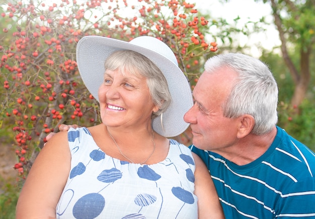 Authentische Außenaufnahme des alternden Paares, das Spaß im Garten hat und mit Liebe gesegnet wird