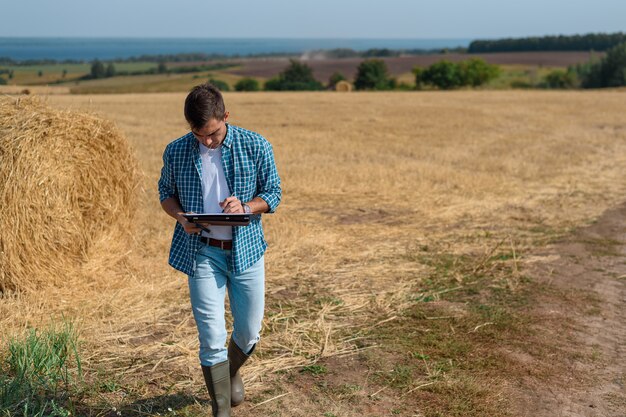 Authentisches Frontporträt des Landwirts des jungen Mannes Landwirt im Heuhaufen