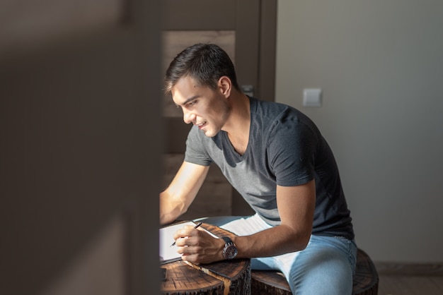 Authentisches Porträt eines Mannes am Tisch, der zu Hause arbeitet