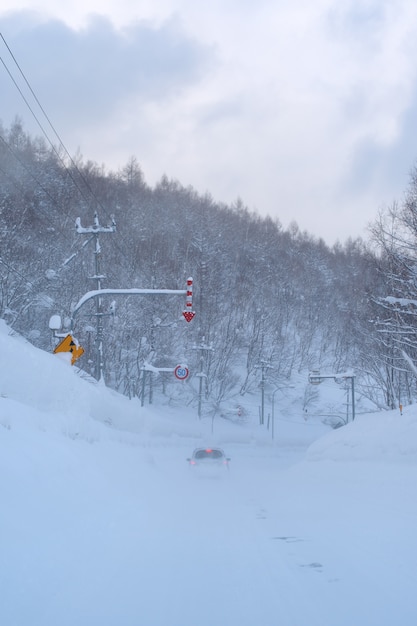 Auto auf einer Bergstraße in einem verschneiten Tag