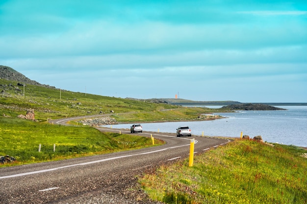 Auto conduciendo en carretera de asfalto por la costa en verano en Islandia