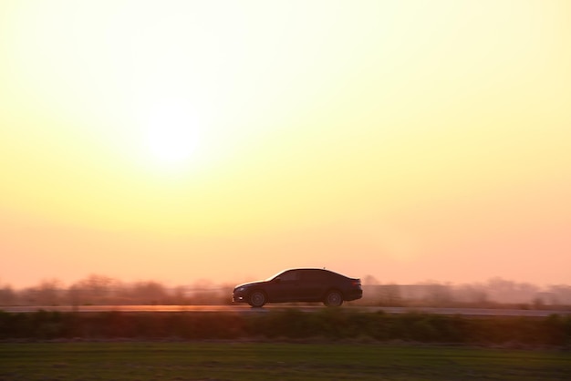 Auto fährt schnell auf der Intercity-Straße bei Sonnenuntergang Autobahnverkehr am Abend