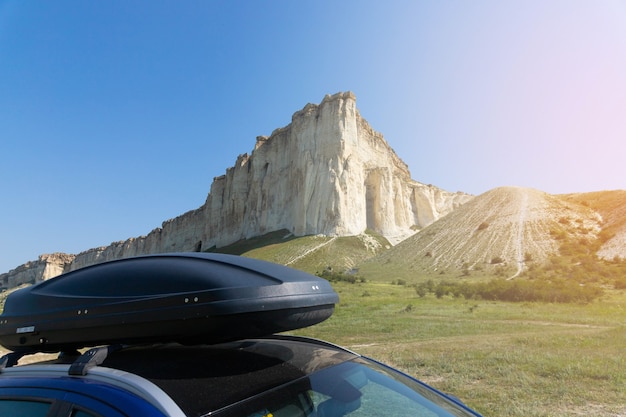 Auto für die Reise mit Dachträger auf einer Bergstraße vor der Kulisse des White Rock. Foto in hoher Qualität