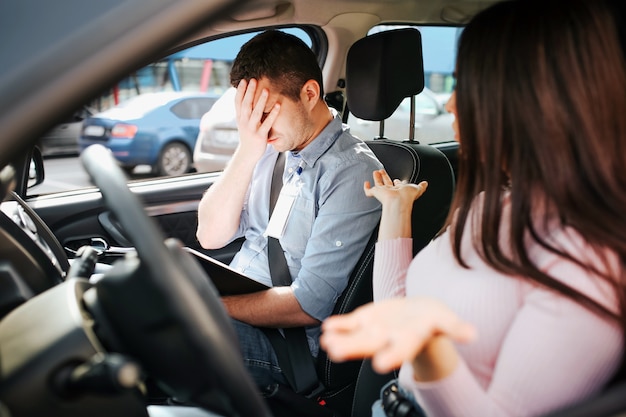 Auto instructor masculino toma examen con mujer joven