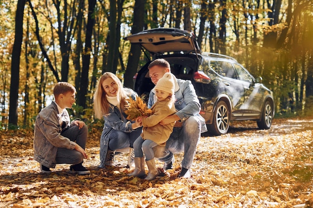 Auto ist hinterher Glückliche Familie ist zur Herbstzeit zusammen im Park