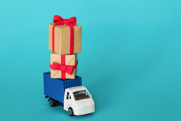 Auto liefert Geschenkbox zum Valentinstag auf blauem Hintergrund Frachttransport-Lieferservice