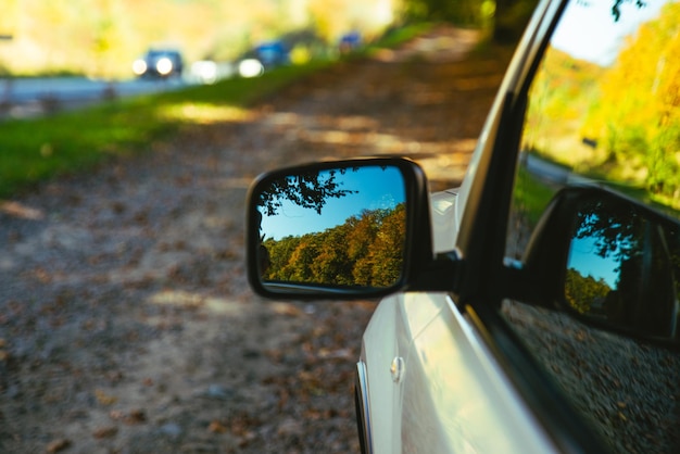 Auto Nahaufnahme Reflexion von gelben Bäumen im Spiegel