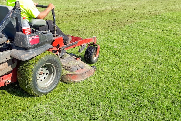 Auto Rasenmäher. Ein Mann fährt einen Rasenmäher. Rasenpflege. Reitmäher. Gras