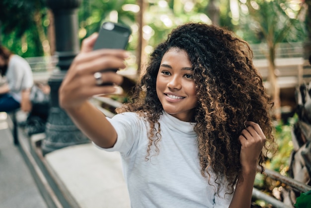 Foto auto-retrato da mulher nova bonita com penteado afro.