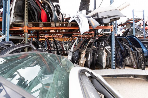 Auto-Teile-Markt. Auf dem Boden sind Türen, Stoßstangen und Windschutzscheiben.