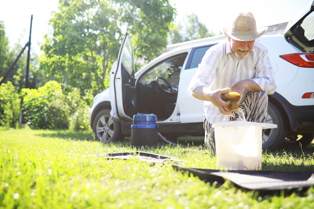 Auto-Trimm-Reinigung Manuelles Auto waschen Ein grauhaariger Mann reinigt sein Fahrzeug