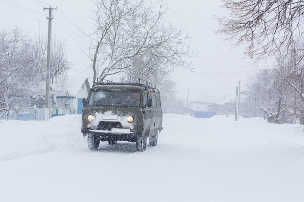 El auto viaja en una carretera nevada. Condiciones climáticas difíciles.