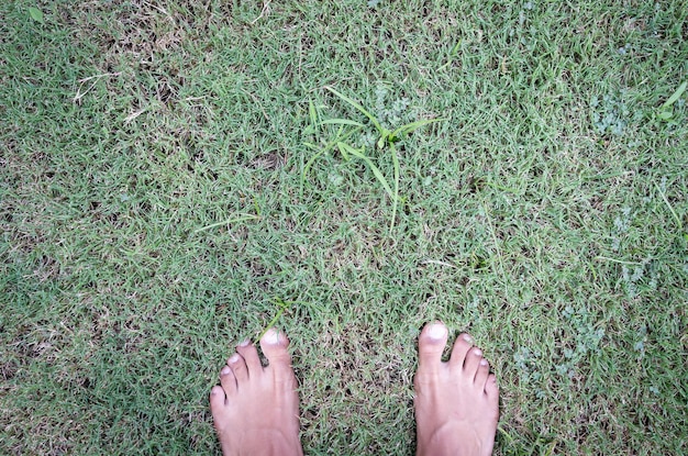 Auto vista de los pies sobre la hierba verde