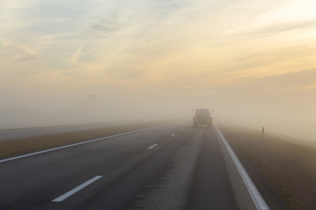 Autobahn und ein Auto im Nebel