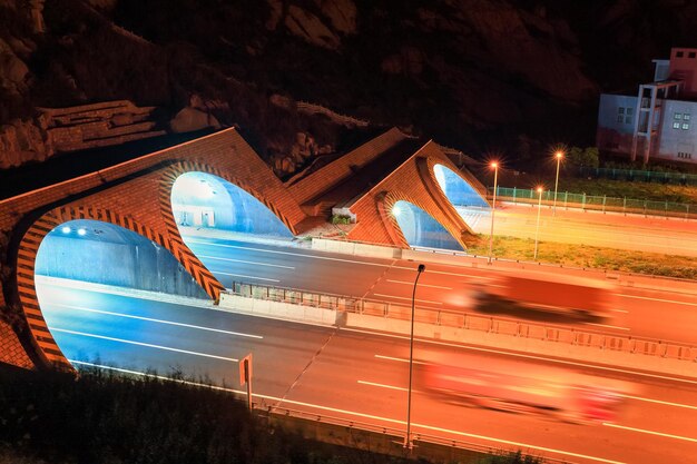 Autobahntunnel bei Nacht und Container-LKW-Bewegungsunschärfe