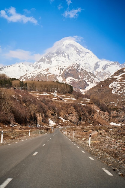 Autobergstraße zum Fuß des Berges Kazbegi Schneekappe auf der Spitze des Berges