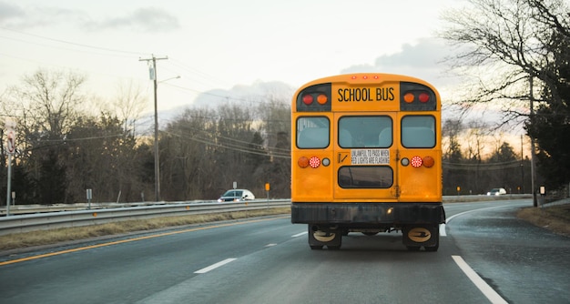 Un autobús escolar amarillo está conduciendo por una carretera.