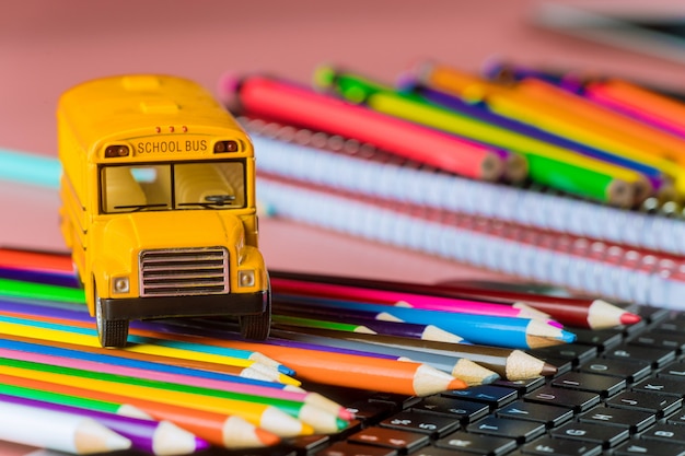 Autobús escolar con lápices de colores y teclado, regreso a la escuela