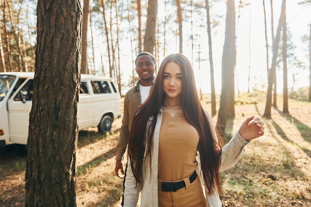 El autobús está detrás Una pareja joven viaja juntos por el bosque durante el día