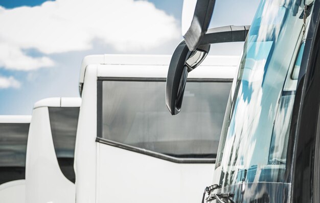 Foto autobuses temáticos industriales y de negocios transporte público de negocios pocos autobuses blancos modernos en el estacionamiento esperando otras rutas