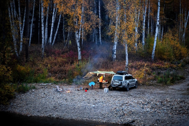 Foto autocamping im herbstwald in der nähe des flusses