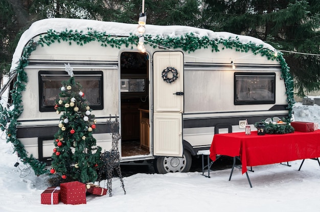Autocaravana autocaravana en camping de invierno decorada para navidad o felices vacaciones de año nuevo
