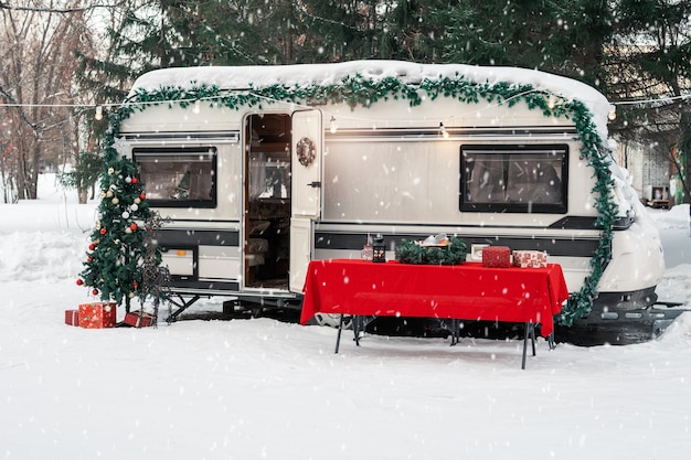 Autocaravana campervan no acampamento de inverno decorado para natal ou feliz ano novo feriado