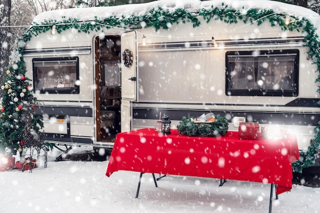 Autocaravana moderna en camping de invierno decorada para navidad o felices vacaciones de año nuevo