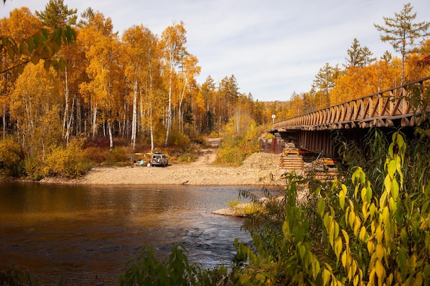 Autocaravana en el río de la montaña en otoño