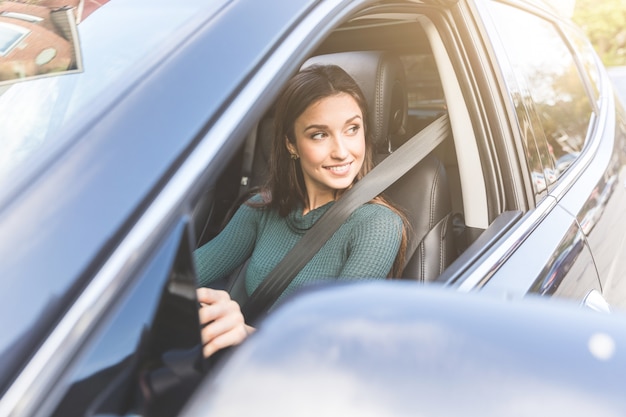 Autofahren der jungen Frau in der Stadt.