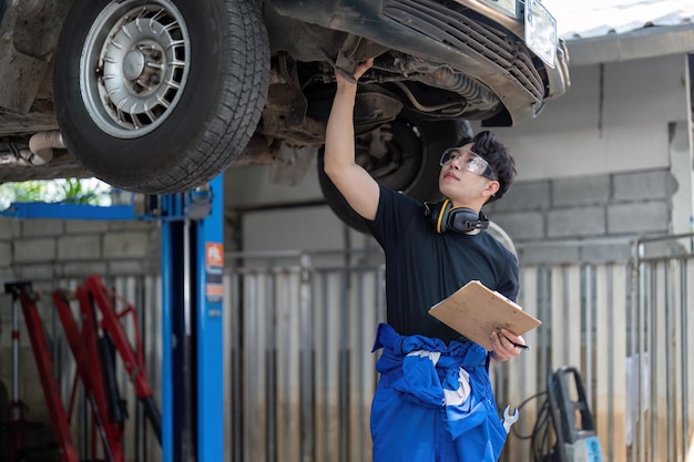 Automechaniker-Autoaufhängungsdetail des angehobenen Automobils an der Reparaturwerkstatt