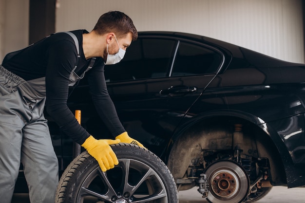 Automechaniker beim radwechsel im auto