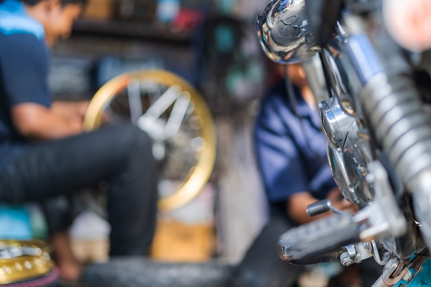 Foto automechaniker, der motorrad in der fahrradreparaturwerkstatt repariert