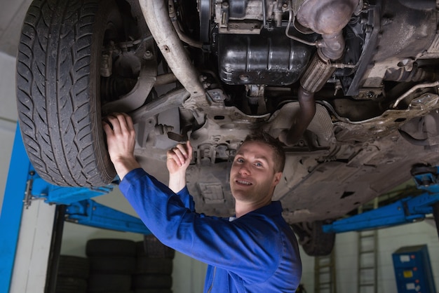 Automechaniker, der unter Auto arbeitet