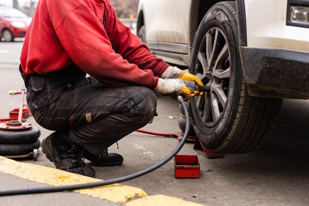 Automechaniker entfernt Radmuttern, um Bremsen zu überprüfen