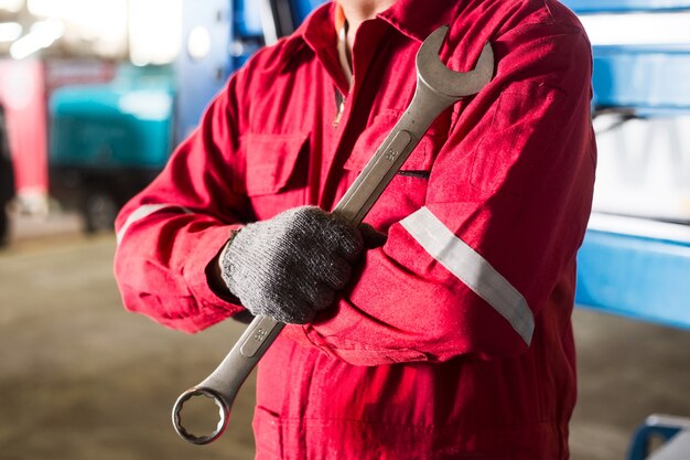 Automechaniker im Overall, der Schlüssel oder Schlüssel hält