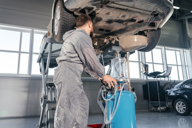 Automechaniker Öl im Motor ersetzen. Auto-Service-Shop