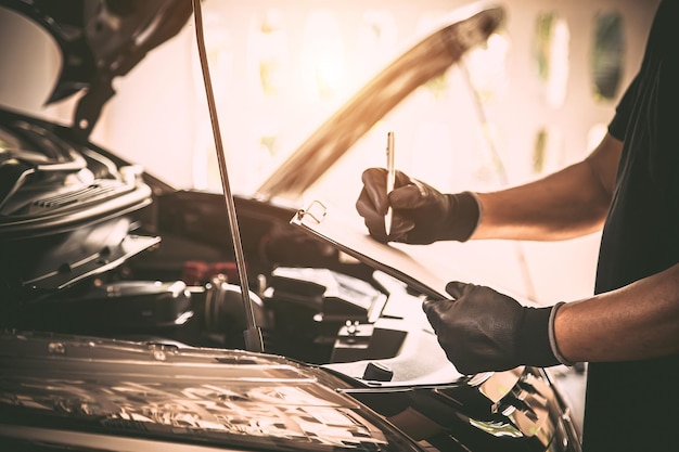Automechaniker mit Checkliste nach Reparatur des Automotorproblems Konzepte der Prüfung und Inspektion der Autopflege, Wartung und Instandhaltung