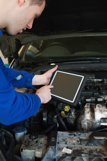 Automechaniker mit dem Auto unter Verwendung des Tabletten-PC