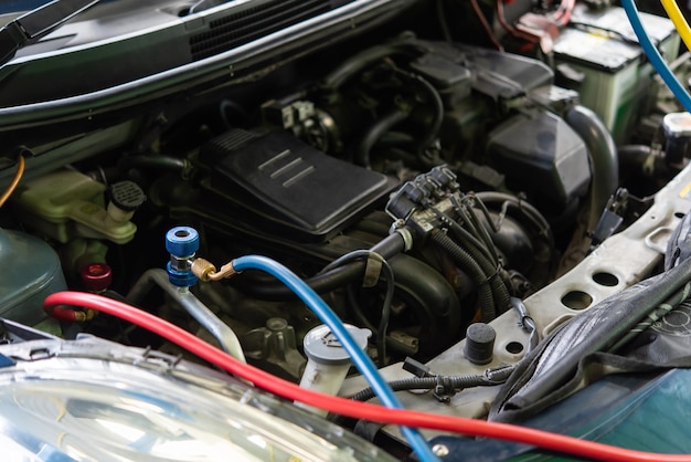 Foto automechaniker oder dienstleiter füllt die klimaanlage wieder auf und überprüft einen luftkompressor auf reparatur