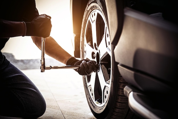 Automechaniker prüfen und verwenden einen Schraubenschlüssel, um den Reifen zu wechseln