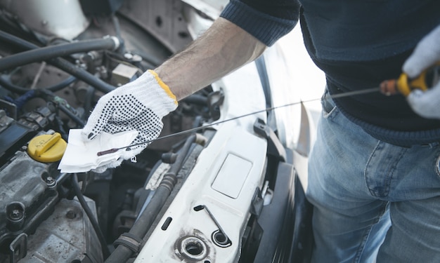 Automechaniker prüft den Ölstand des Automotors