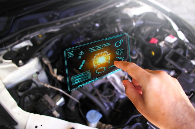 Automechaniker überprüft ECU-Motorsystem mit drahtlosem OBD2-Scanner und Fahrzeuginformationen, die auf der Bildschirmschnittstelle angezeigt werden. Konzept des Fahrzeugwartungsservices
