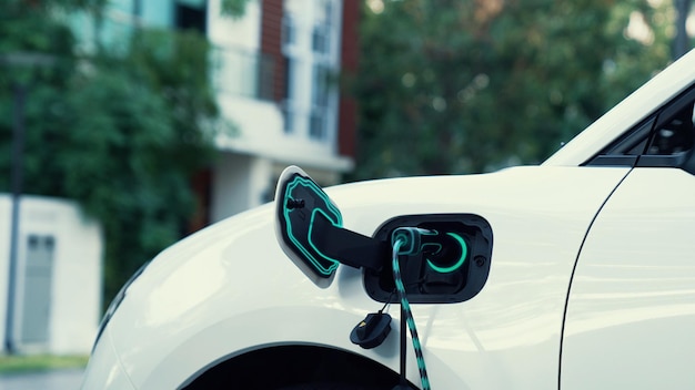 El automóvil eléctrico conectado con la estación de carga doméstica para recargar la batería por el cable del cargador de vehículos eléctricos El futuro del automóvil eléctrico innovador y la sostenibilidad energética La infraestructura energética doméstica inteligente y futurista Peruse.